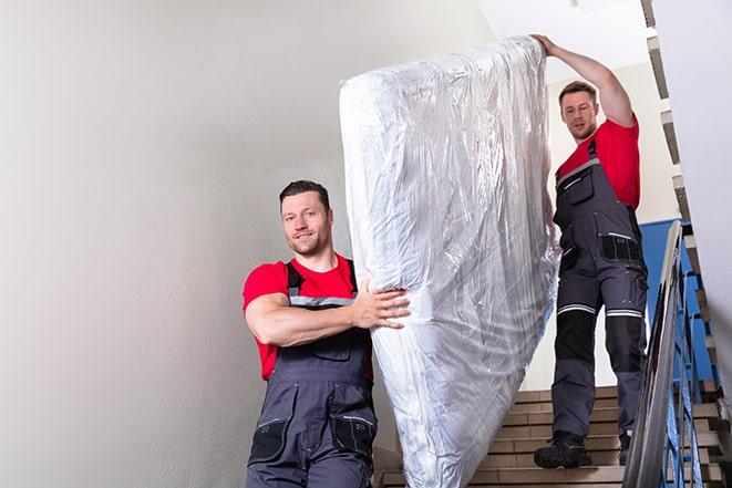 two people disposing of box spring from bedroom in College Park